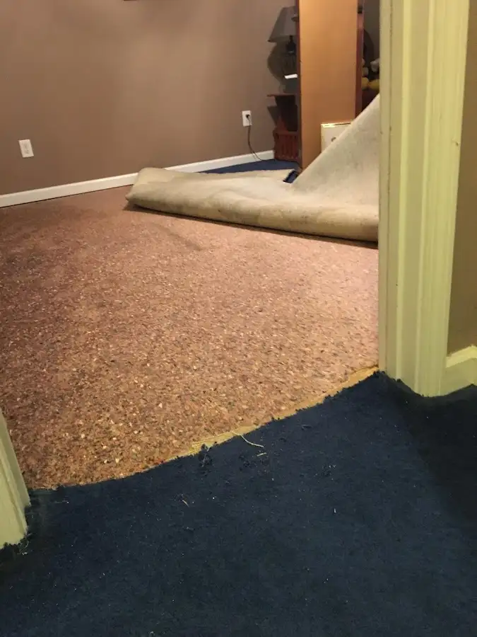 Carpet pad removal revealing water damage during Water Mitigation Services in Howard